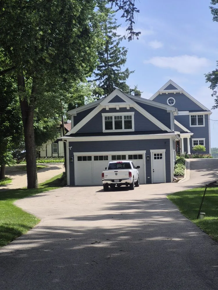 Navy lake house and garage with white trim and board and batten gables
